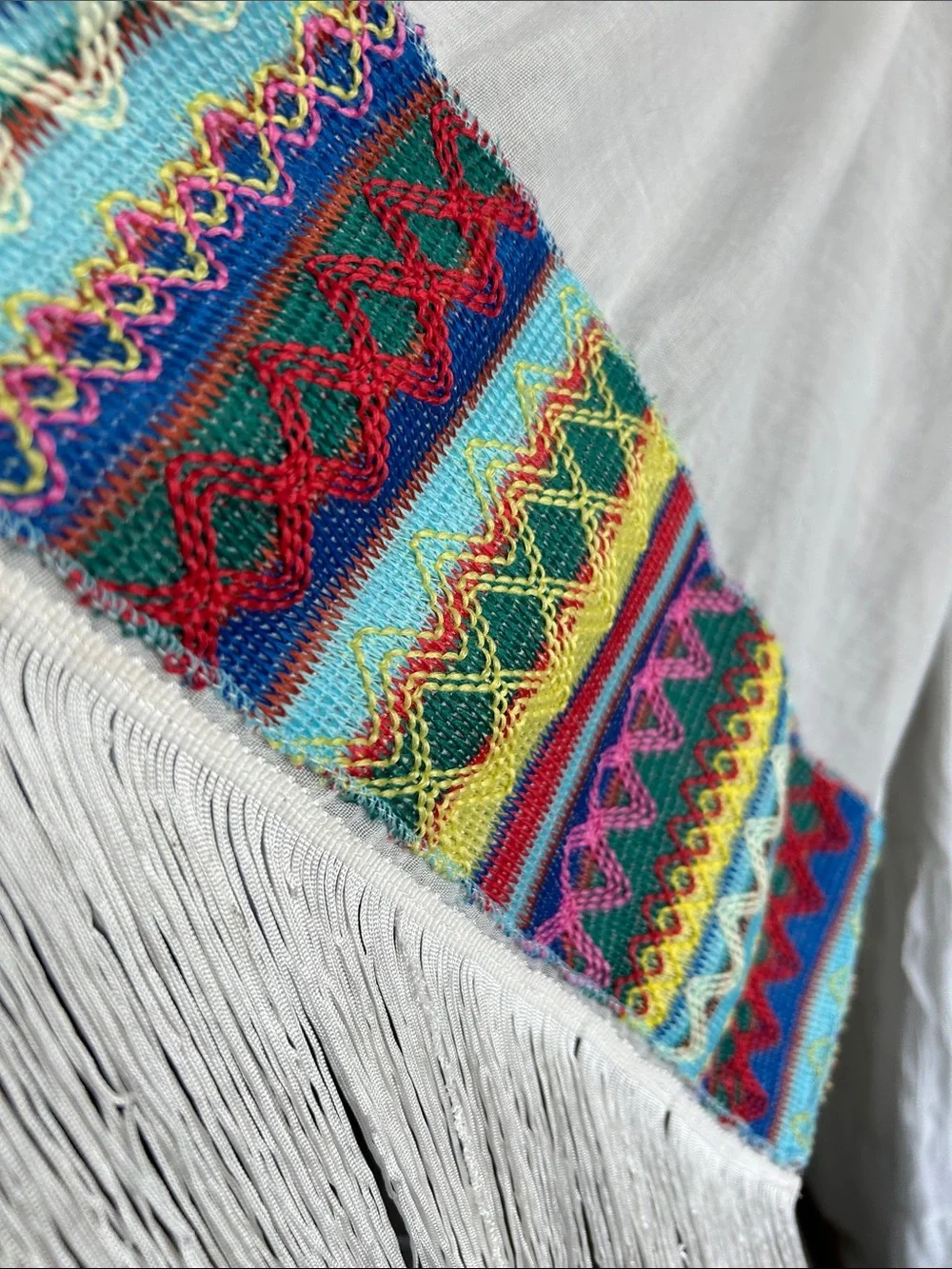 World Market white fringe scarf with red blue yellow green stitching